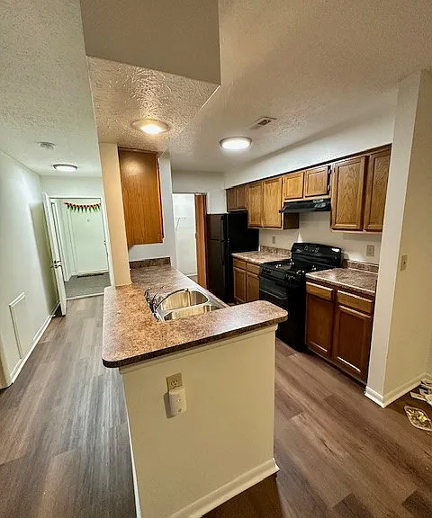 The kitchen has new counters, a new black stove and a black dishwasher, and a refrigerator