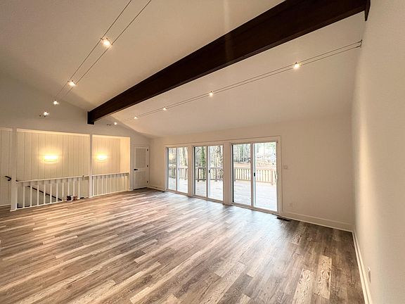 Living room, with view of deck and fireplace opposite windows