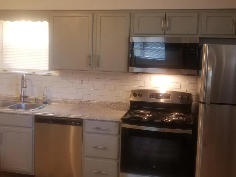 Newer Kitchen with stainless steel appliances. Refrigerator, dishwasher, stove, microwave.