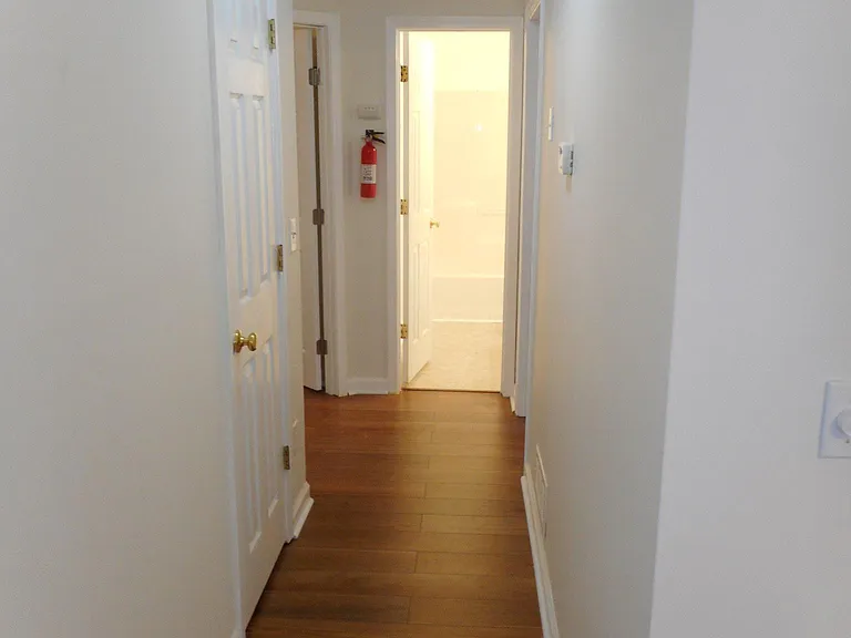 Hallway to bedrooms off the lounge with closet. New laminate