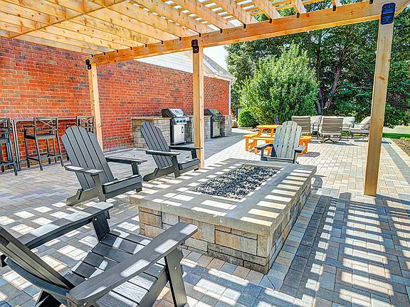Host your next hangout under the pergola with cozy seating and a gas fire pit perfect for evening relaxation.