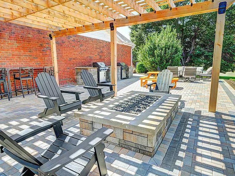 Host your next hangout under the pergola with cozy seating and a gas fire pit perfect for evening relaxation.