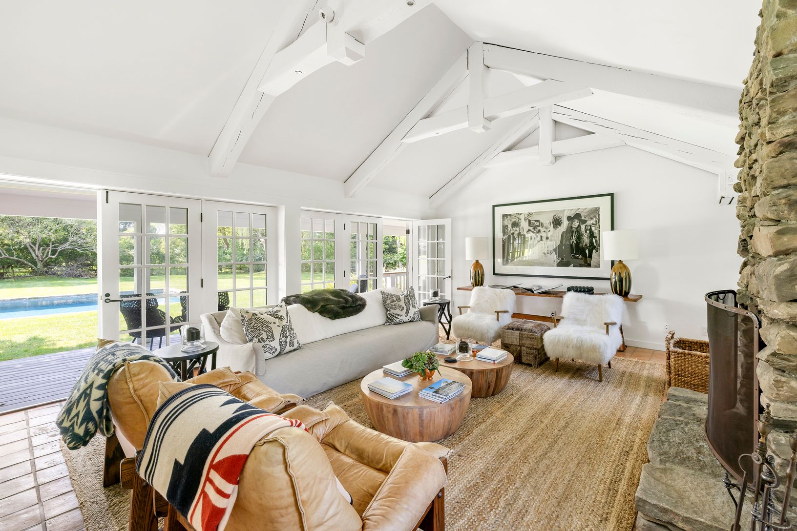  Living Room with Floor to Ceiling Fireplace flanked by Covered Porch overlooking Pool