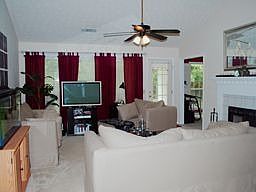 Large open living room with vaulted ceiling and fire place. Large open windows