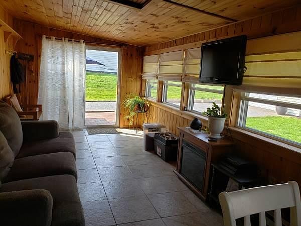 Beautiful sunroom with tile floor and windows across the entire back.