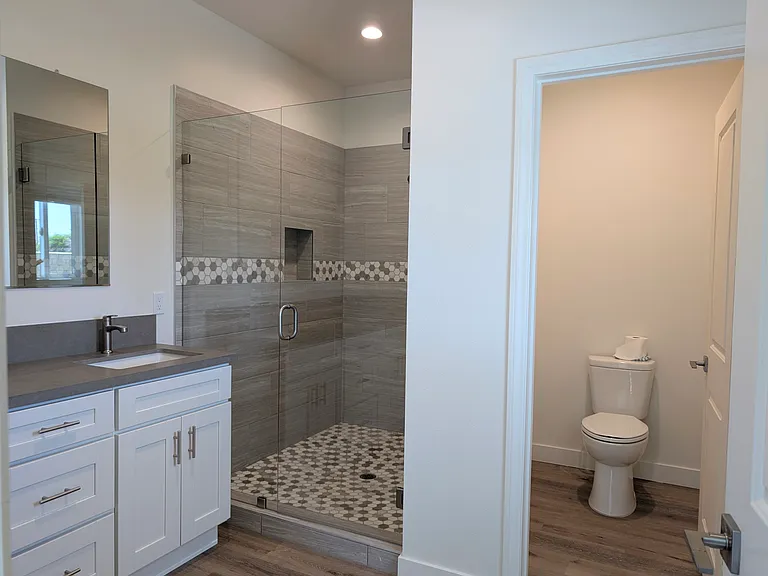 Primary bathroom with huge shower, double vanity and private toilet room