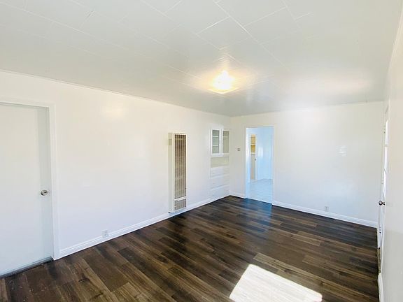 Living room with door to bedroom 1 and the kitchen/dining opening entrance