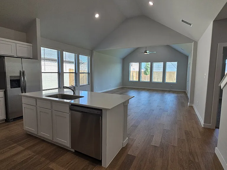Modern open floor plan with high ceilings and abundant natural light throughout the heart of the home