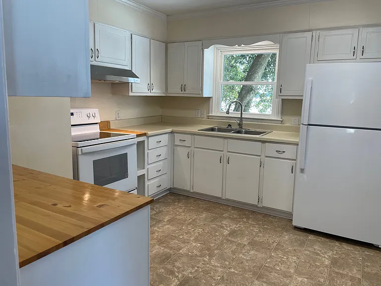 Spacious kitchen with lots of counter space and 27 cabinets and 11 drawers, a large desk, large new refrigerator, and washer and dryer hookups.
