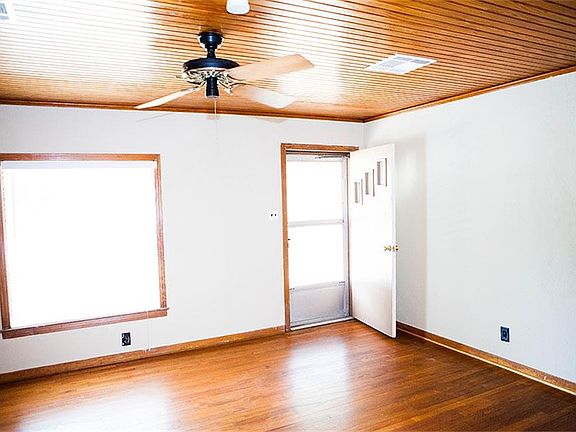 Large family room with ceiling fan and original solid oak floors.