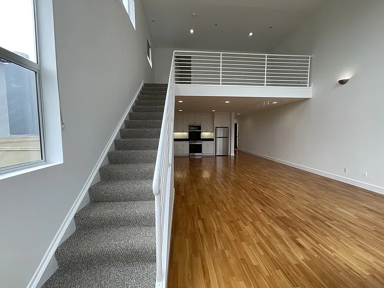 Staircase leads to the upper level primary suite and bonus loft area.