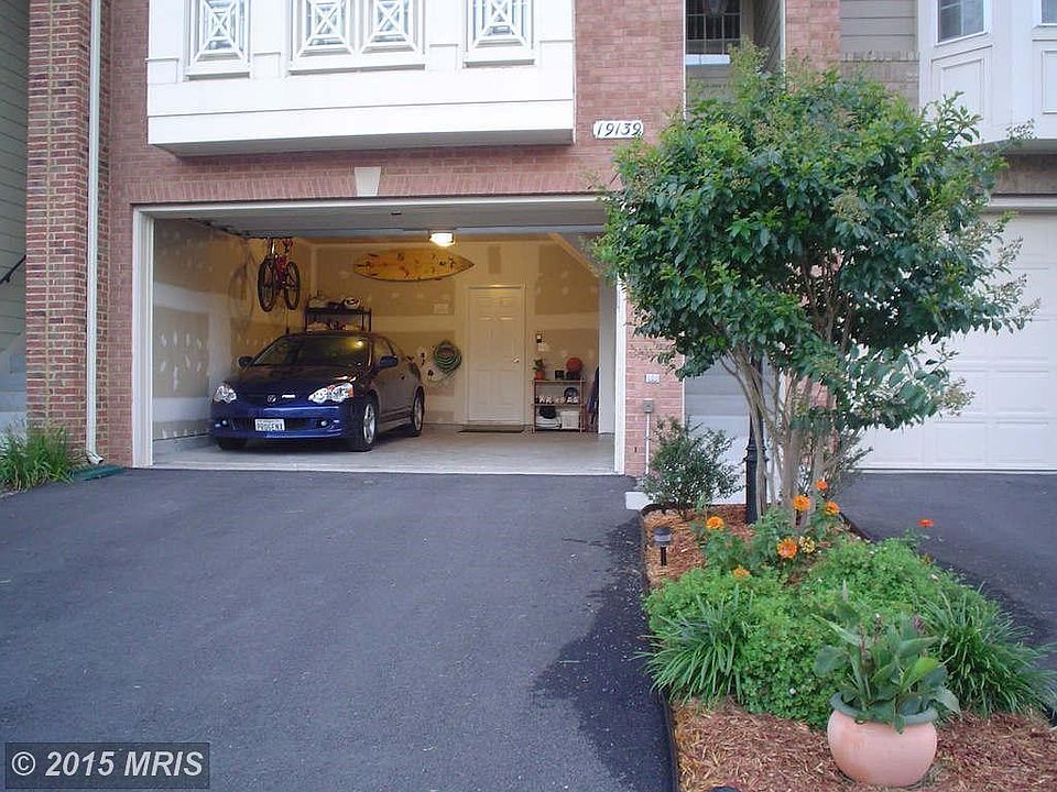 Two car garage with flowerbed infront of entrance