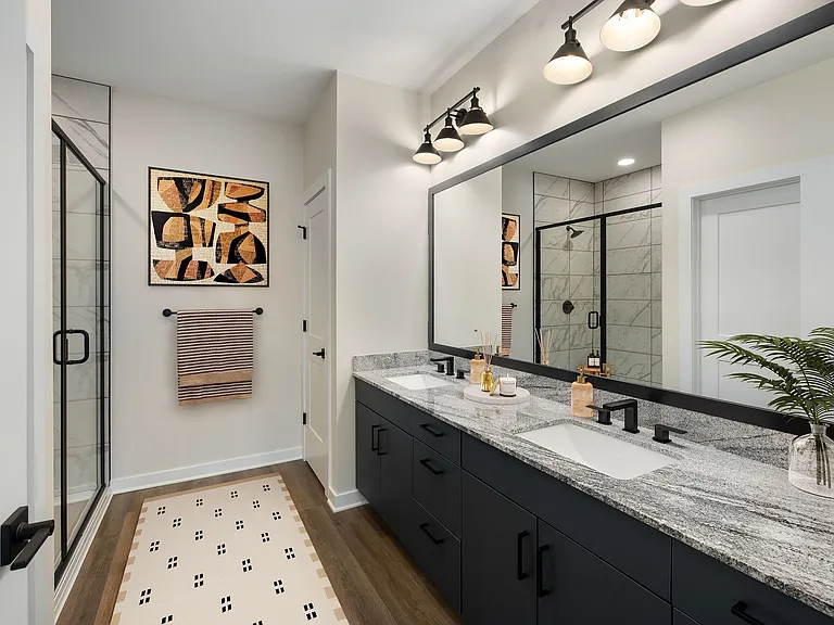 Townhome primary bath with granite counters and sleek glass shower.