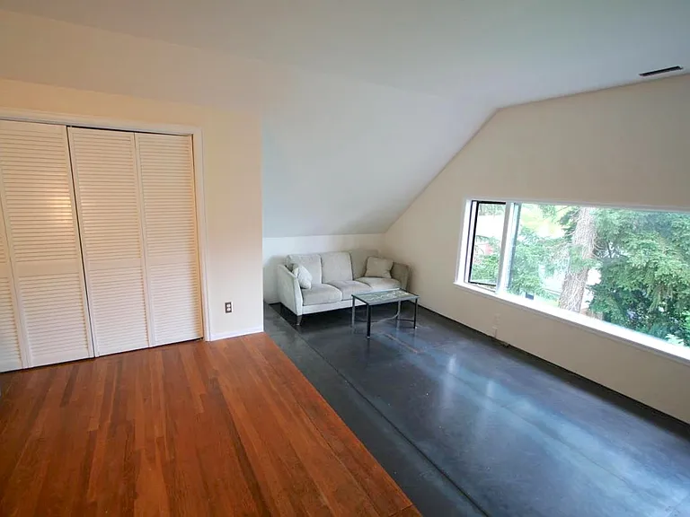 primary (very large) bedroom set up as an office with big picture window facing west overlooking lush back yard and garden.
