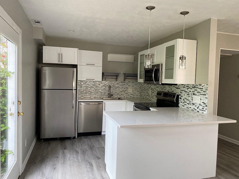 Newly Renovated Kitchen with quartz countertops, stainless steeel appliances, soft close cabinets, pendant lights, and an eat in bar!