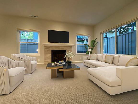 Inviting living room with new carpet, abundant natural light, a luxury gas fireplace, and recessed lighting.