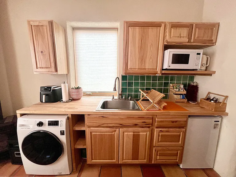 Casita/mother-in-law quarters kitchenette with washing machine and mini fridge.