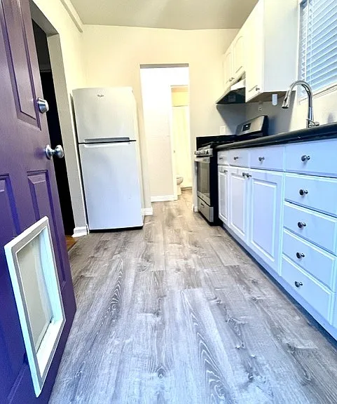 Kitchen entrance-new flooring, gas stove, new sink fixture and fresh paint throughout