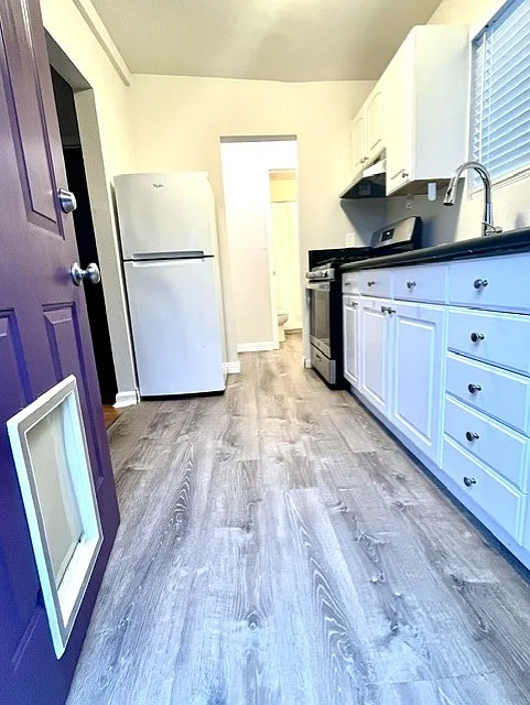Kitchen entrance-new flooring, gas stove, new sink fixture and fresh paint throughout