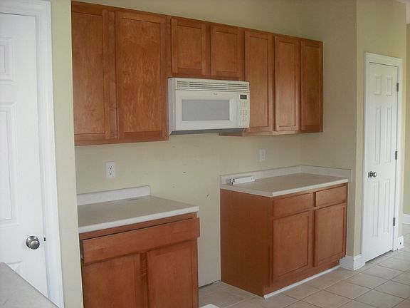 Kitchen w/ 2 pantries leading to back door, garage, and 1/2 bath.
