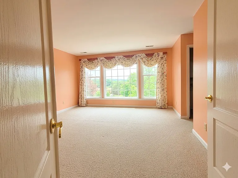 Spacious master bedroom with double entry doors.