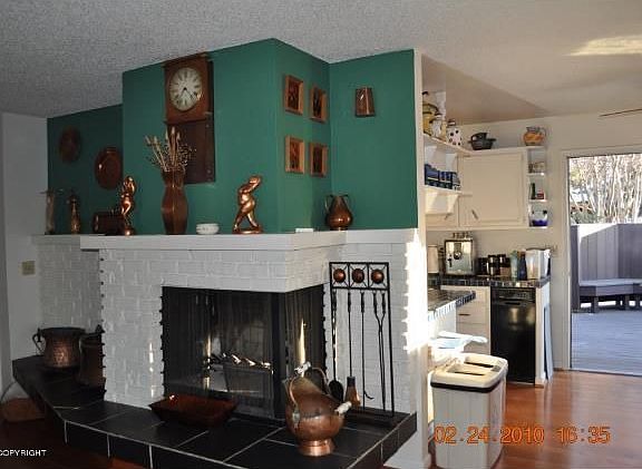 Fireplace, kitchen and door to deck