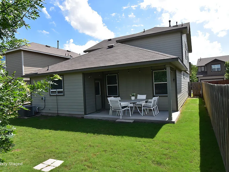 Virtually staged covered patio overlooking the backyard.