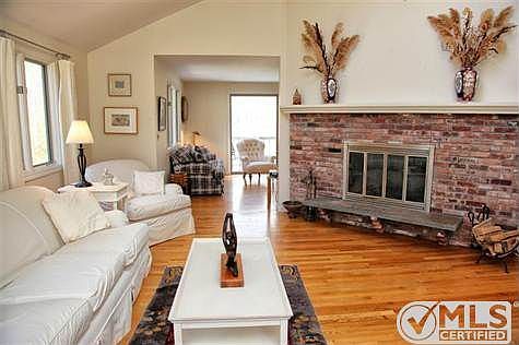 Dramatic living room with cathedral ceilings and wood-burning fireplace.