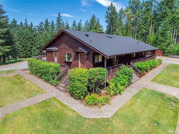 View from opposite side of home, large deck surrounds the home entirely with ramp access on far side.