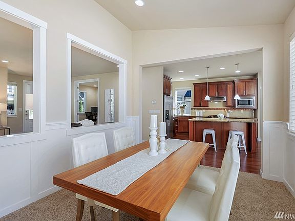 Formal dining room with lofty ceiling and wainscot walls with wall of windows.