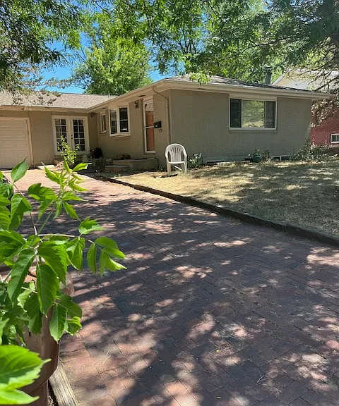 View of front of the house from the street. Shows the shared one car garage and entrance to the upstairs apt.