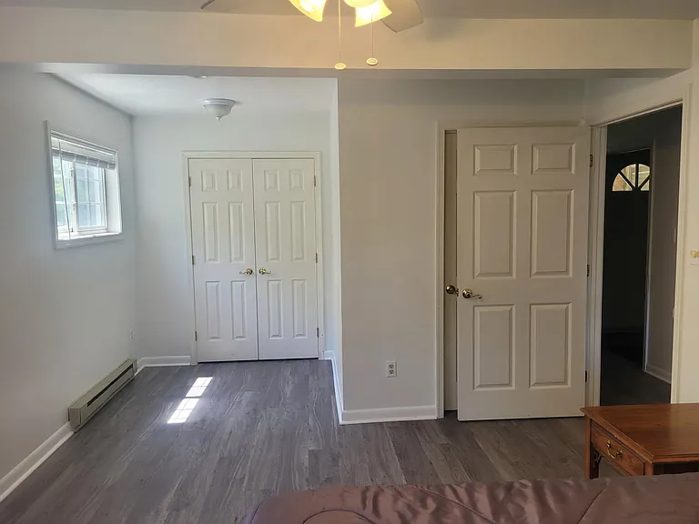 Closet doors opposite bed. Door on right is bathroom.