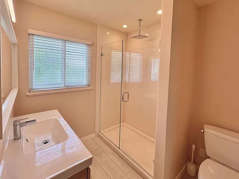 The bathroom features a beautiful walk-in glass shower.