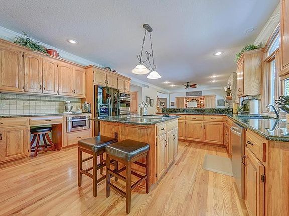 Huge open kitchen with black granite counter tops, sit up bar, walk in pantry, built in stainless steel appliances.  Opens into the living room, to the breakfast nook, then onto the pretty sunroom.
