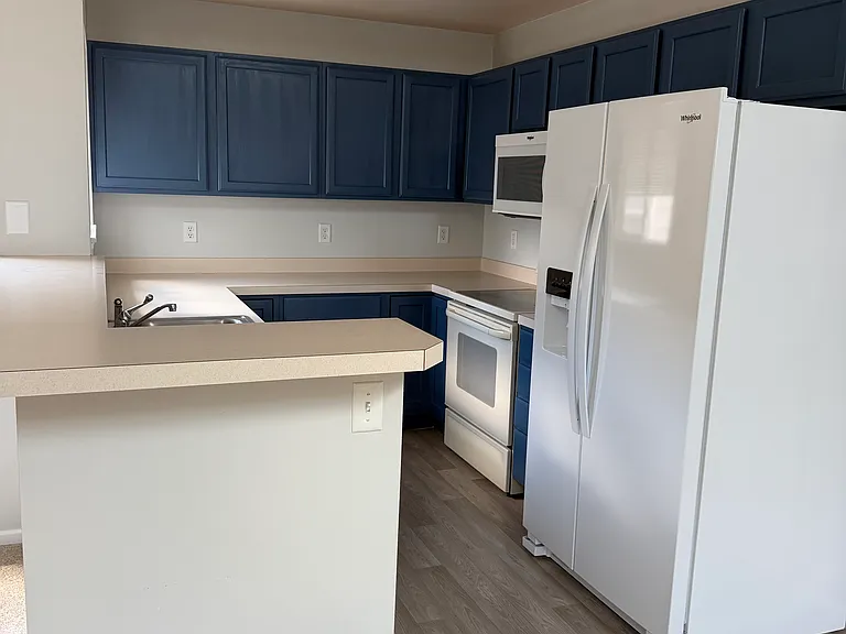 Kitchen with year old refrigerator and microwave