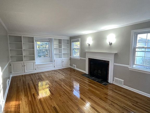 Living room with wood-burning fireplace and built-in library