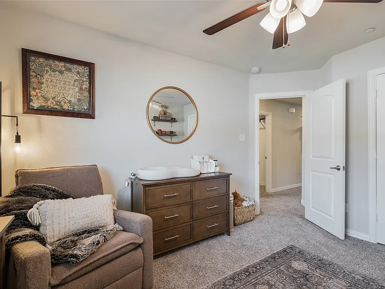 Carpeted room featuring a ceiling fan with integrated lighting, a paneled door, and light gray wall paint