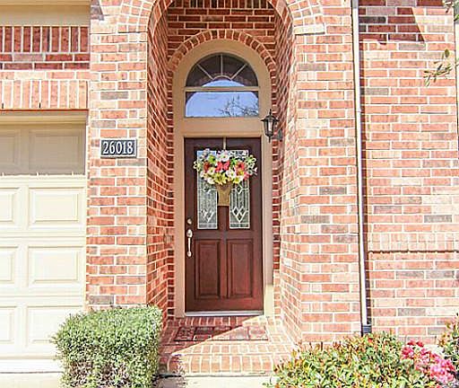 The entry is beautiful and fully-bricked. This covered entry also features a leaded-glass front door