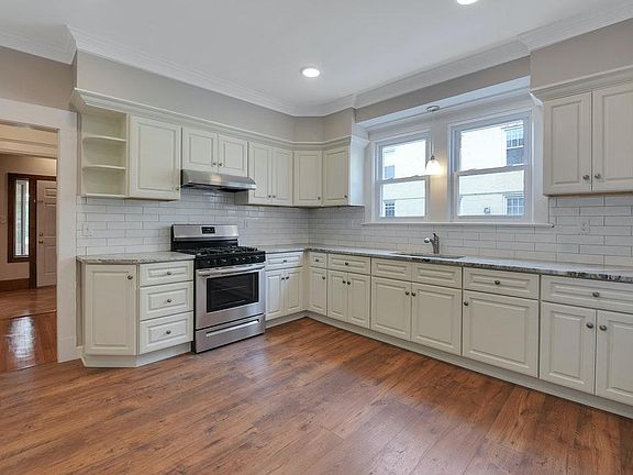 Remodeled Kitchen Large kitchen with eat in space includes laminate flooring, white cabinetry, gas range/oven and fan, standard size refrigerator, subway tile, granite countertops and recessed lighting. Incredible prep space!