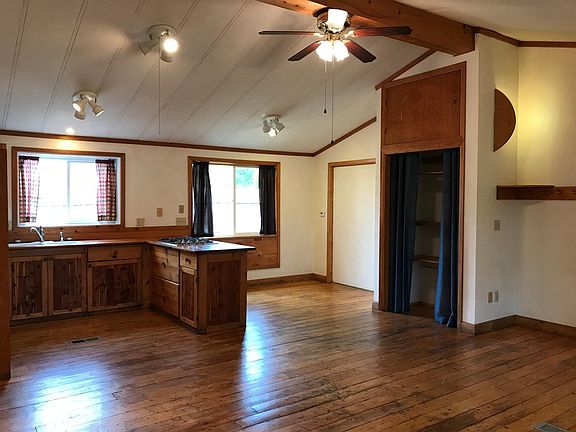 There is a closet with a storage area above it in the main living area. The closets have curtains instead of doors. The floors are distressed knotty pine.