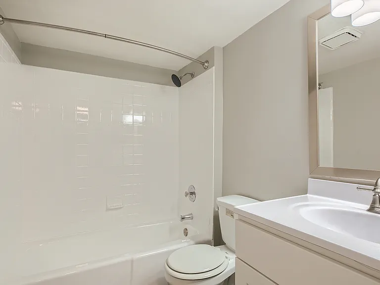 Contemporary bathroom featuring sleek fixtures, a pristine white bathtub, and a stylish vanity with a modern mirror.