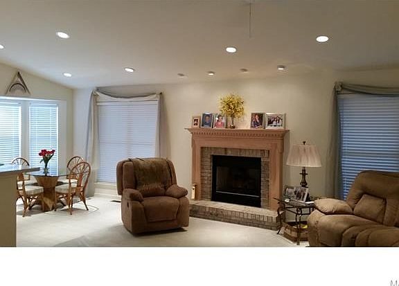 Vaulted great room with fireplace and lots of can lights open to the dining area.