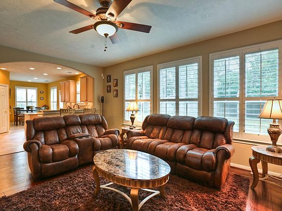 Spacious living room with fireplace and plantation style shutters.