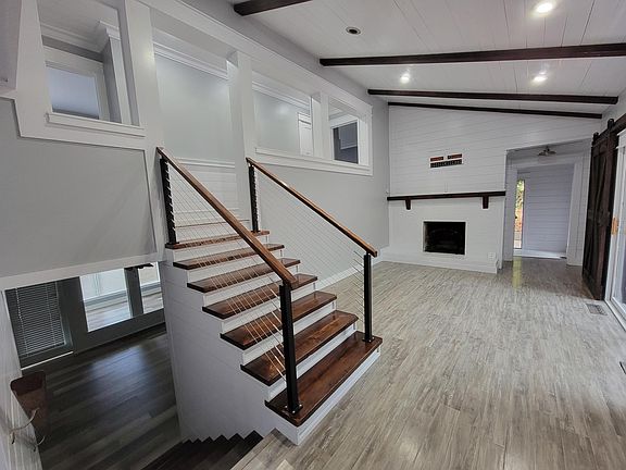 Opposite view of fireplace room. Stairs up to bedrooms and stairs down to lower den/dining, sunroom, kitchen and laundry.