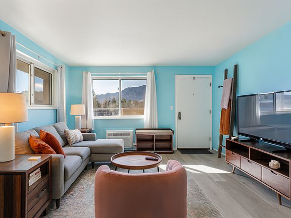 Soak in mountain views from this bright and welcoming living room _ a cozy retreat that feels both playful and peaceful the moment you arrive.