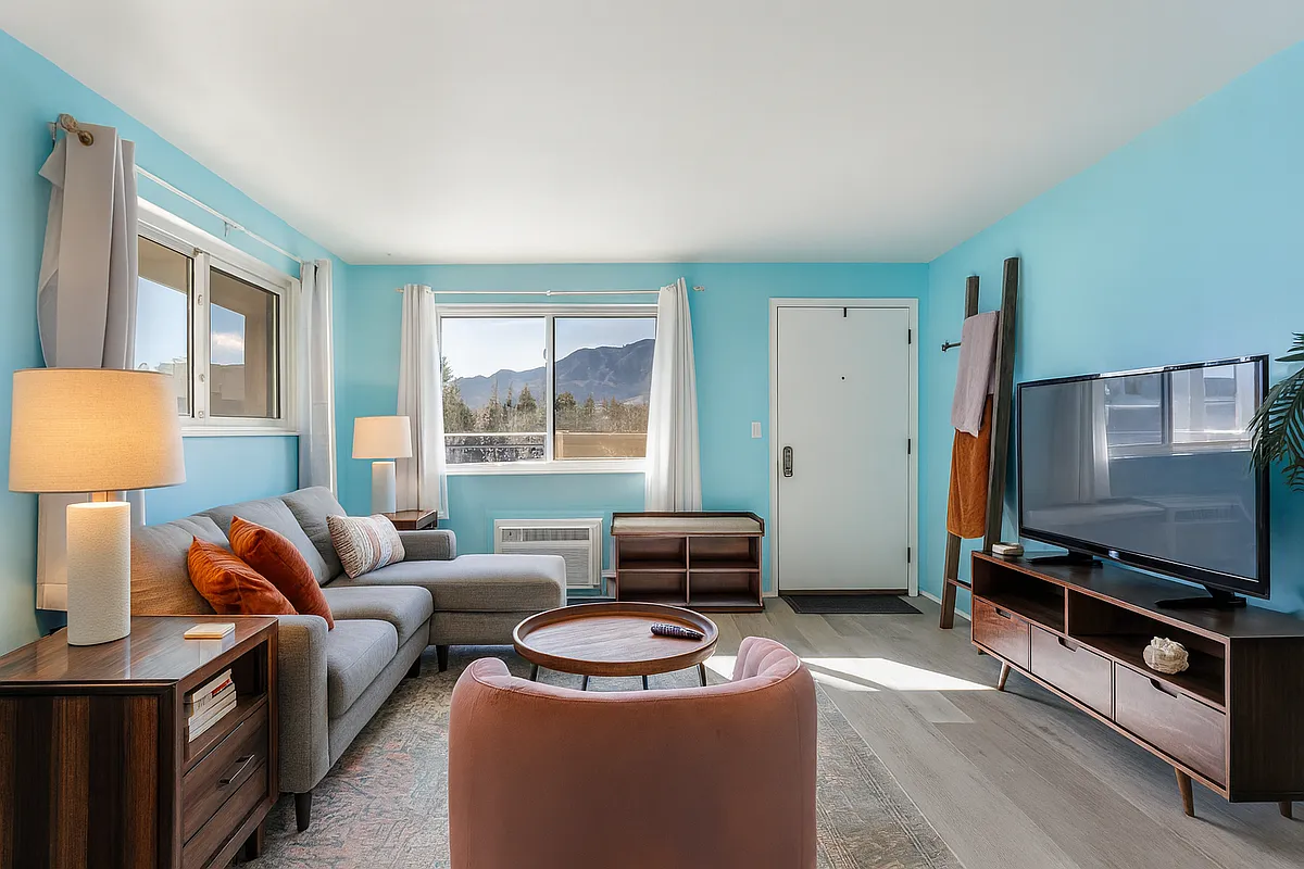 Soak in mountain views from this bright and welcoming living room _ a cozy retreat that feels both playful and peaceful the moment you arrive. - Manhattan Pl