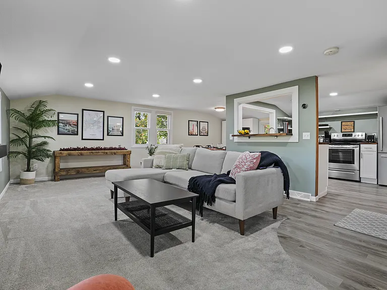 Open concept living with the living room, dining and kitchen area. The living room has a comfy couch, 58" smart TV, and corner swivel chair that's perfect for morning coffee and sight seeing the neighborhood.