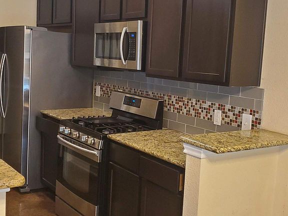 As you walk in you see the stainless steel appliances and granite counter tops in the kitchen.