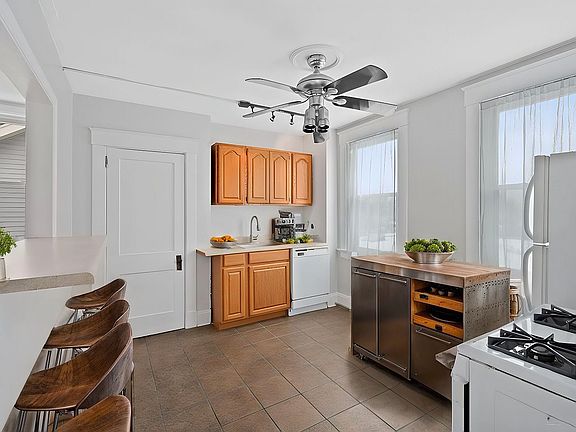 Large eat in kitchen with pantry, counter bar, dishwasher, fridge and gas stove.