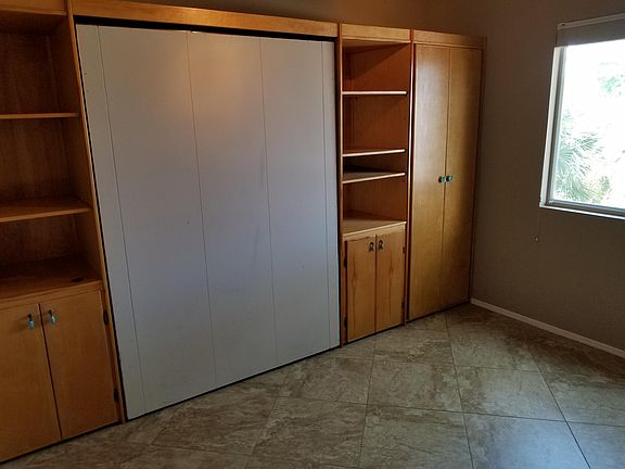 Front bedroom with wall units and hide-a-bed.